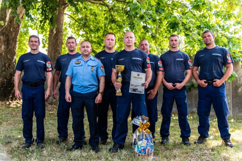 A teljes ajkai csapat parancsnokukkal, Bárány Gábor tűzoltó alezredessel és Csillag István tűzoltó ezredes, vármegyei igazgatóval. Geiger Máté középen, a serleggel Fotó: Szőke Péter BM OKF